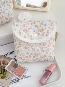 Gros plan sur la trousse à maquillage en coton matelassé à fleurs avec bouton-pression