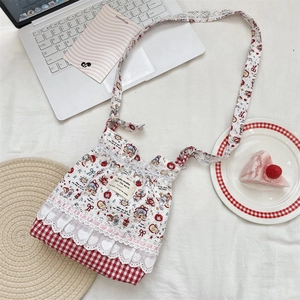 Détail d'un sac à bandoulière style japonais à carreaux rouges avec dentelle et motifs fleuris