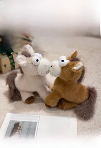 Gros plan de deux poneys en peluche drôles avec de grands yeux et sourire édenté