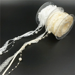 Detail showing white and beige lace ribbons with pearl beads for gift wrapping