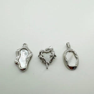 Close-up of 18K gold plated silver pendants with natural white shell in irregular shapes