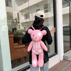 Pink teddy bear backpack with Y2K punk bone pattern and star applique details on model