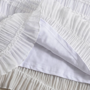 Détail d'une robe blanche à rayures montrant le tissu texturé et la doublure lisse