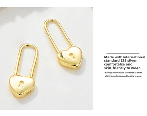 Close-up of 925 sterling silver heart-shaped padlock earrings with gold-plated finish