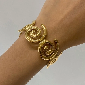 Elegant gold spiral cuff bracelet in minimalist stainless steel for a luxury wrist look