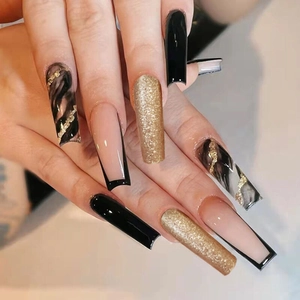 Detailed view of long square press-on nails with black, gold glitter, and marble patterns