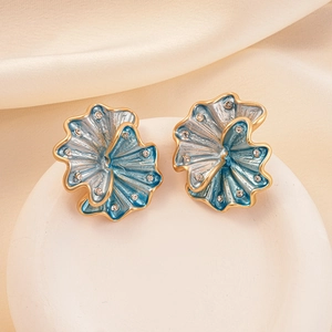 Close-up of blue enamel flower earrings with gold edges and sparkling crystals