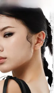 Primo piano di ear cuff minimalisti in oro e argento sull'orecchio di una modella