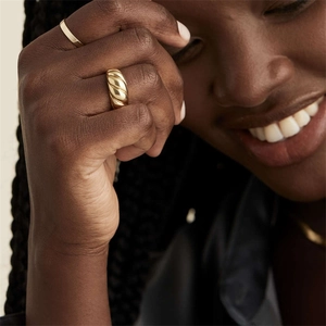 Stacked set of gold croissant twist ring and slim band on female model finger