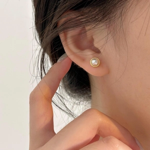 Detailed close-up of a 925 sterling silver pearl earring with gold beaded texture