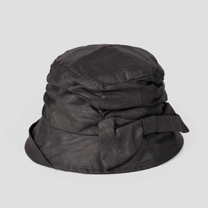 Detalle de un sombrero de sol de ramio negro con lazo elegante y textura de tejido sarga