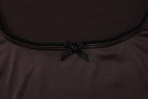 Détail du col carré avec bordure en dentelle noire et petit nœud décoratif
