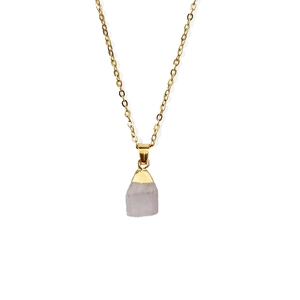 Macro shot of natural rose quartz raw stone pendant with gold metal top and fine chain