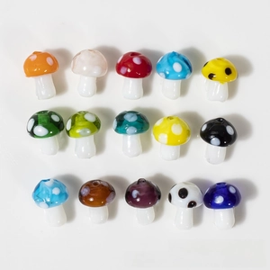 Macro view of fifteen handmade colorful glass mushroom beads with contrasting polka dots