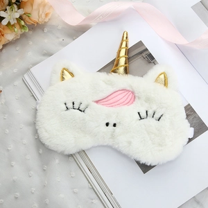 Detailed view of plush unicorn sleep mask with golden horn and soft white faux fur