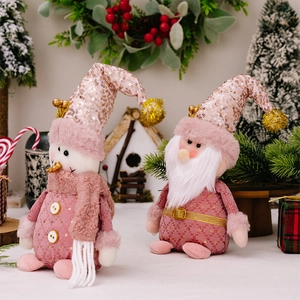 Pink sequin Christmas plush dolls featuring a snowman and a gnome in a festive setting