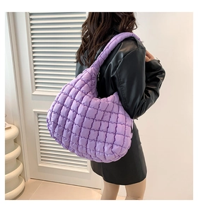 Close-up of a purple quilted puffy tote bag with soft square pattern and thick shoulder strap