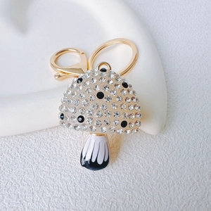 Close-up of golden mushroom keychain featuring crystal rhinestones and lobster clasp