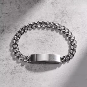 Macro detail of silver stainless steel curved bar on a chunky curb chain bracelet