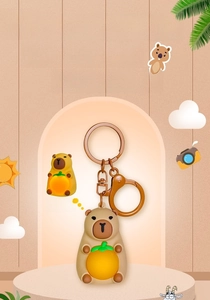 Detail of Capybara keychain with glowing orange ball and antique bronze metal hook