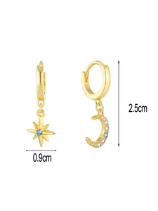 Detail view of asymmetric gold star and moon earrings with blue and white zircons