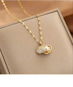 Close-up of 18k rose gold shell pendant necklace with pearl and sparkling crystal details
