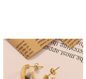 Close-up of C-shaped twisted rope earrings in two-tone gold and silver braided design