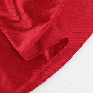 Vue macro du satin rouge révélant la texture soyeuse et les coutures de la robe