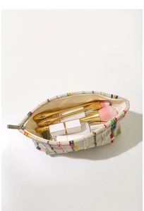 Vue intérieure détaillée du sac cosmétique en tricot rayé avec pinceaux et maquillage