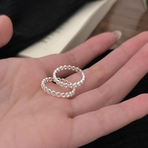 Macro detail of two S925 sterling silver rings with hollow heart patterns for women