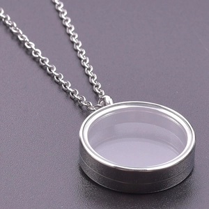 Macro shot of a silver stainless steel floating locket pendant with glass and metal chain