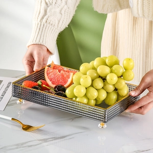 Modern grey translucent glass fruit tray with gold trim and crystal support feet
