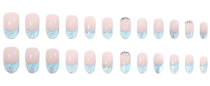 Detail of pink French press-on nails with light blue swirls and rhinestone accents
