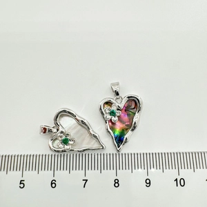 Detailed size view of heart pendants with shell inlay and green gemstone flower detail