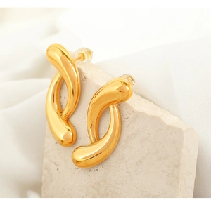 Macro shot of 18k gold plated geometric hoop earrings with abstract twisted texture