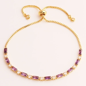 Detail of adjustable gold bracelet with purple rectangular and white round zircons