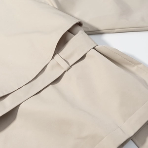 Gros plan détaillé du tissu tissé beige du trench-coat et du passant de ceinture