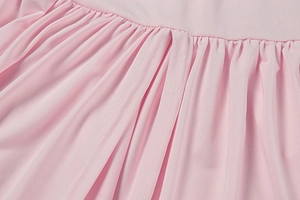 Detail of pink fabric showing professional gathered pleats and clean double stitching