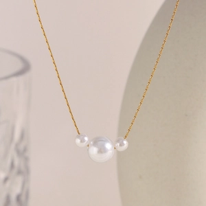 Elegant 18K gold plated stainless steel necklace featuring three pearl pendants in symmetry
