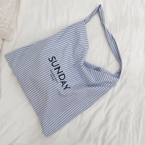 Detailed close-up of blue and white striped canvas tote bag with Sunday Summer Night text