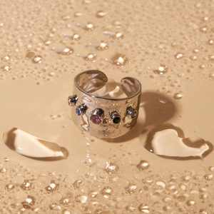 Silver hammered wide band ring with colorful zircons on water droplet background