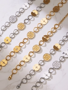 Detail of PVD gold and silver necklaces with zircon coin pendants on white marble surface