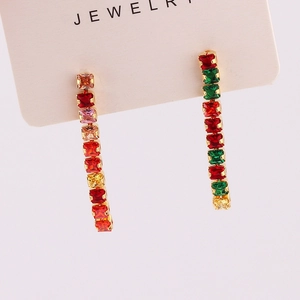 Detailed macro view of colorful rectangular rhinestones set in gold tassel earrings