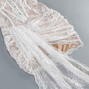 Détail de dentelle florale blanche avec doublure beige et liens croisés délicats