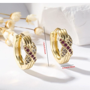Detail of gold zircon earrings with dimensions 1.4cm by 0.5cm and red stone inlay