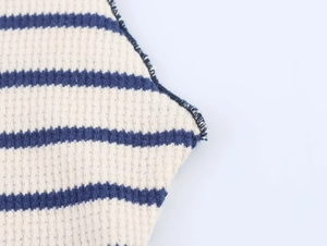 Macro view of blue and white striped waffle knit fabric detail and overlock stitching