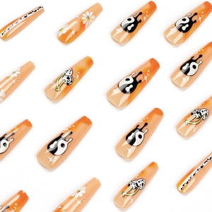 Faux ongles à presser orange et nude avec motifs yin yang, fleurs et champignons