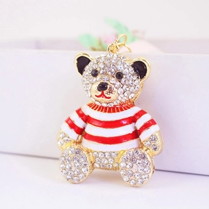Golden teddy bear keychain with sparkling crystals and red striped sweater accessory