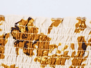 Détail de smocks plissés et imprimé floral sur un tissu blanc mélangé de coton