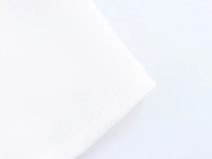 Dettaglio delle cuciture pulite e della trama del tessuto bianco di un abito